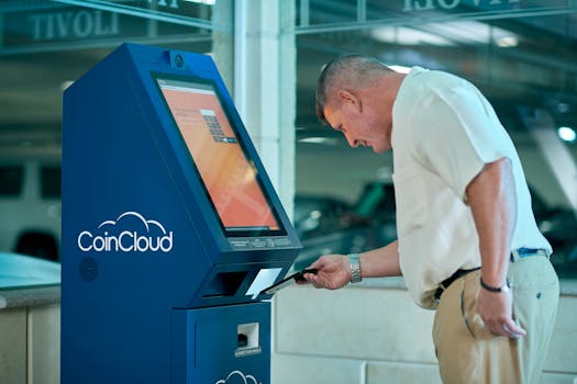 Adult man interacting with Coin Cloud digital currency machine indoors, demonstrating modern technology usage.